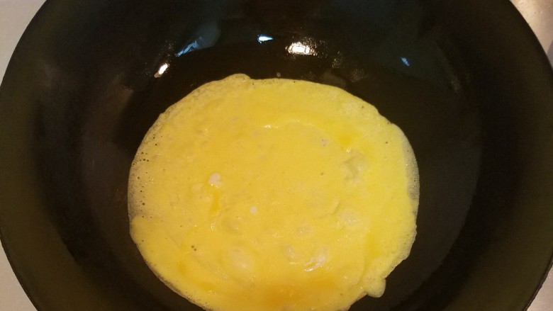 波点蛋包饭,小火热锅，锅里抹层薄油把鸡黄液倒入锅中，转动锅使蛋黄液流动均匀铺满锅底成圆形蛋饼。