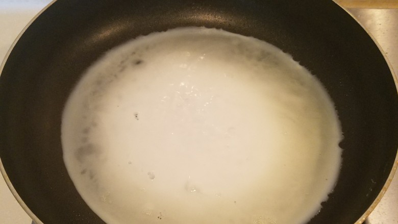 波点蛋包饭,把蛋清液倒入锅中，同样转动平底锅使蛋液成圆形蛋饼。