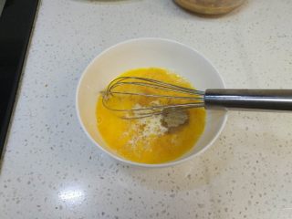炸鸡排（非油炸版）,两个鸡蛋打散，并加入牛奶和白胡椒粉搅拌均匀