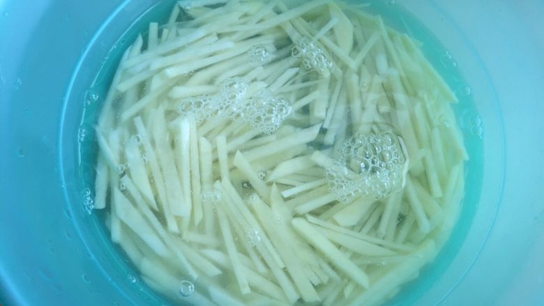 三彩土豆丝,切好的土豆丝泡入水里洗洗，洗去些许淀粉。