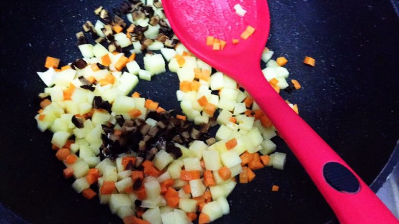 电饭锅土豆腊肠饭,放入红萝卜丁，继续翻炒10秒