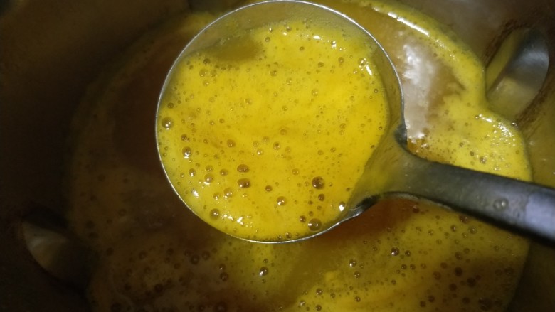养生美颜甜品——玫瑰南瓜银耳露,煮好的银耳露金黄色的，由于加了银耳，有些泡泡，用个勺子撇去不要