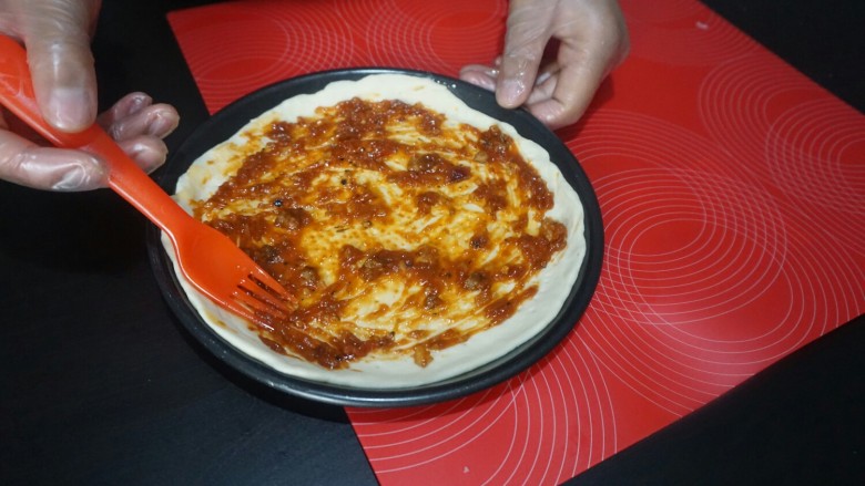 独家秘制香肠披萨,用勺子，在披萨饼底部。涂抹均匀即可。