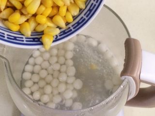 玉米圆子甜酒酿,圆子煮熟浮起来时，就可以倒入玉米粒。