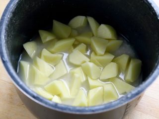 香肠土豆焖饭,5.将土豆块平铺在大米上。