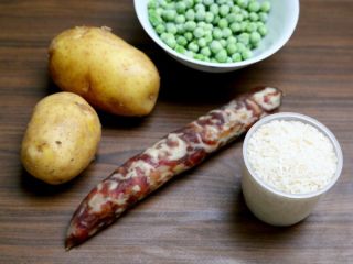 香肠土豆焖饭,1.备好材料：大米加糙米300克、香肠1根、土豆2个、速冻豌豆100克
