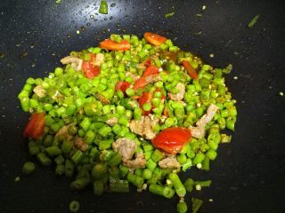 豆角煲仔饭,锅内下入植物油，把青椒的、瘦肉、西红柿下锅炒至8成熟备用。