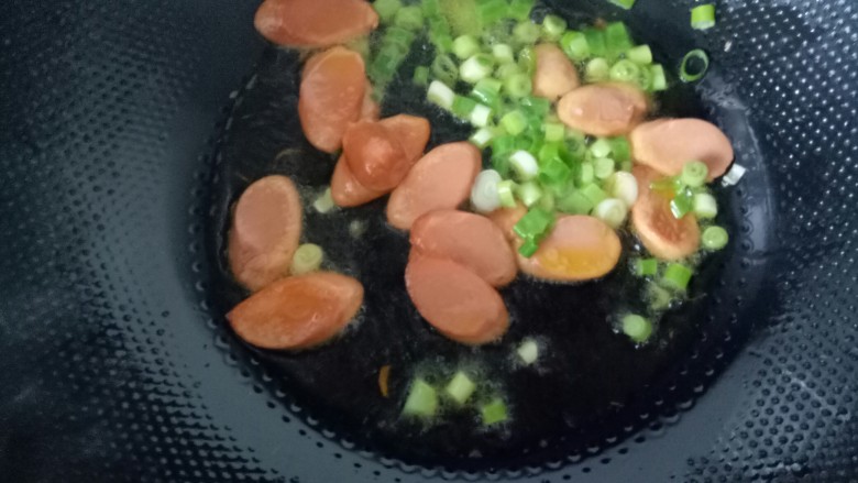 火腿肠炖土豆,放入葱花翻炒。