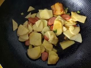 火腿肠炖土豆,放入土豆片，加耗油、鸡粉，翻炒。