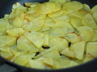 孜然洋葱土豆片,锅中倒适量食用油烧热后，放入土豆片小火煎炒
