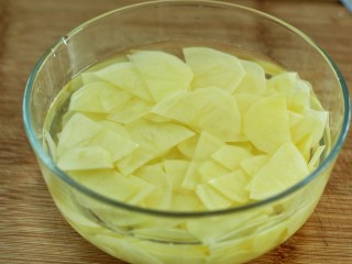 孜然洋葱土豆片,用清水冲洗掉表面淀粉，沥干水分备用
