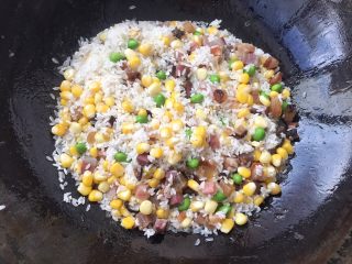 土豆腊肉焖饭,继续翻炒，让腊肉与米饭香味融合！