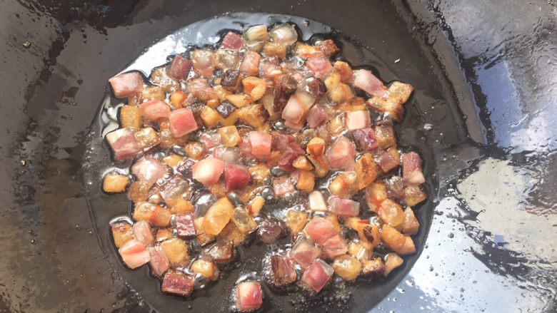 土豆腊肉焖饭,肥油提炼出来后，瘦腊肉一起倒入锅中翻炒片刻。