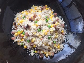 土豆腊肉焖饭,翻炒至看到大米完全吸收腊肉油分就可以了。