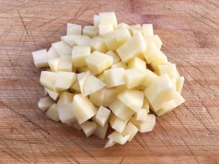 土豆腊肉焖饭,用刀切成小块方便食用。