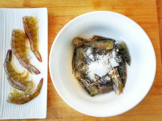 鲜香蒜爆土豆虾+焦香椒盐虾头~(一虾两吃不浪费),下面是制作煎虾头的步骤。
剪下的虾头，放入适量的淀粉，食盐，胡椒粉，抓拌均匀，