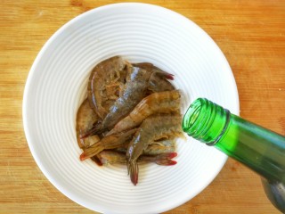 鲜香蒜爆土豆虾+焦香椒盐虾头~(一虾两吃不浪费),处理干净的虾放入碗中，加少许的料酒，食盐，腌制一下
