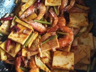 干锅香辣虾,最后放入炸好的虾和土豆条，让底料均匀裹在食材上，放少许鸡精，少许糖，炒匀即可出锅。