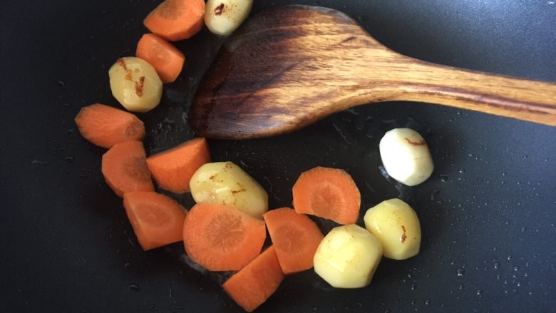 杂蔬培根奶炖,待小土豆煎至表面微黄就放入胡萝卜一起煎炒