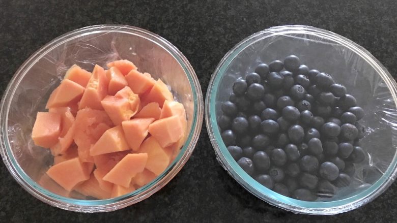 蓝莓木瓜思慕雪,把木瓜和蓝莓装入可以冷冻食品的容器里，包上保鲜膜，