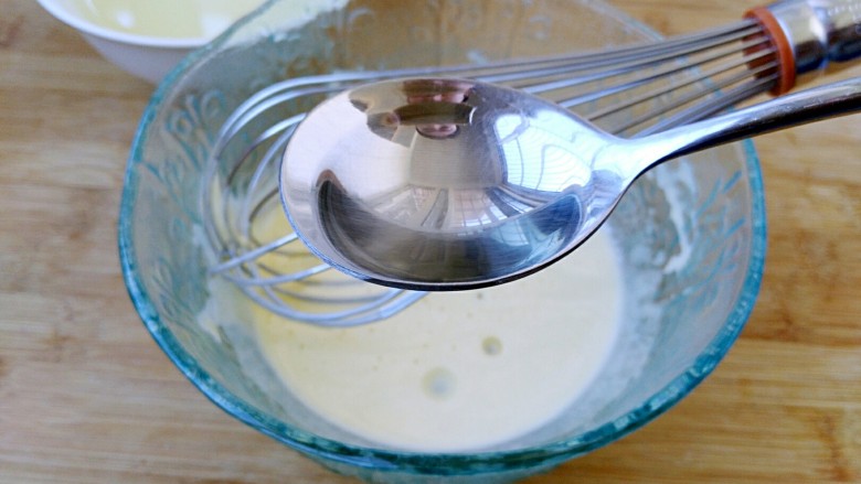 自制蛋黄沙拉酱,加入一小勺油（刚开始一定要少加油），继续搅拌，至油和蛋黄融合。