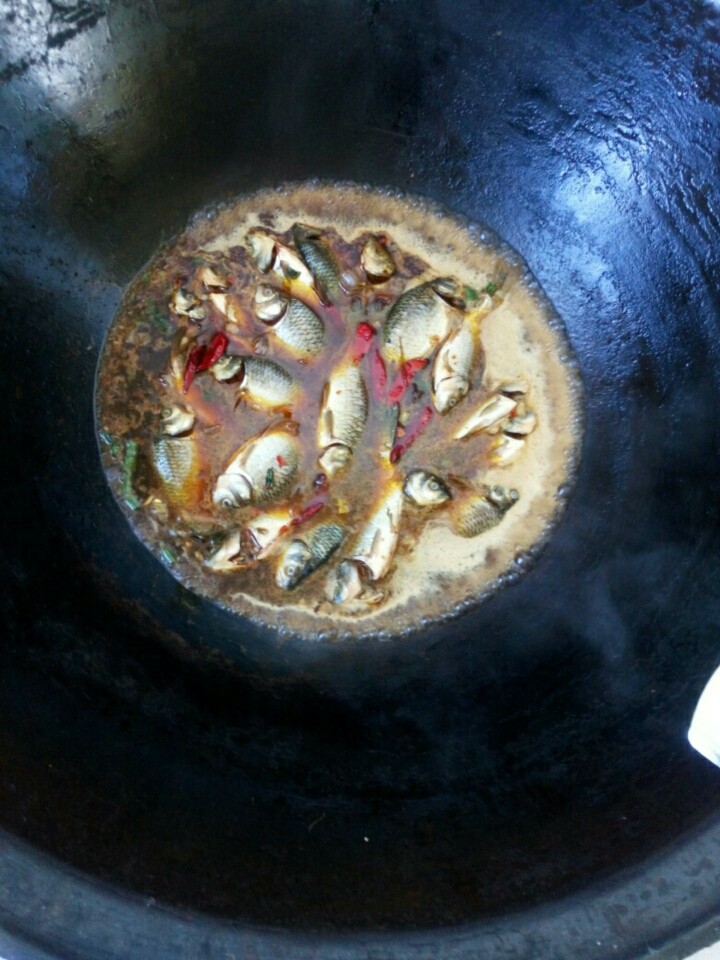 酱炖鲤鱼,锅中倒入适量水，把鲫鱼放进锅中，放入少量料酒，待锅开再盖锅，(水开是为了去腥。)