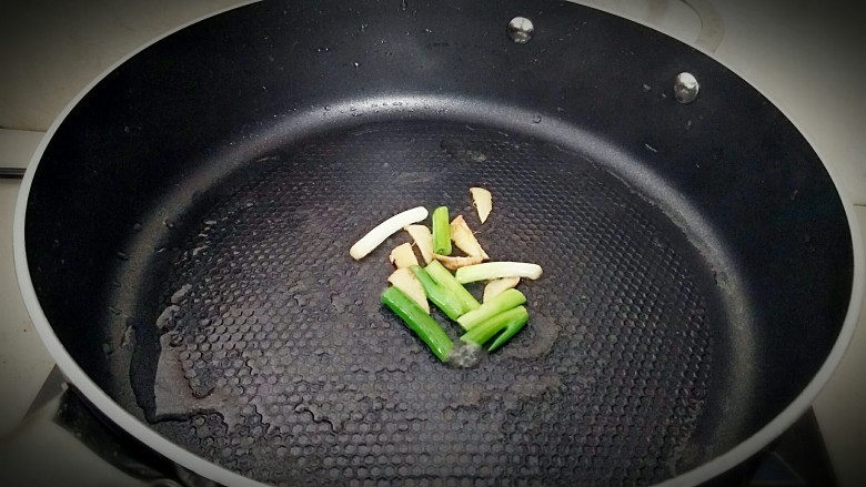 家常版溜肉段,锅中刷一层油，放入葱姜炝锅。