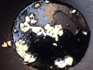 丝瓜蚬子汤,锅中倒入适量底油加热放入蒜片爆香