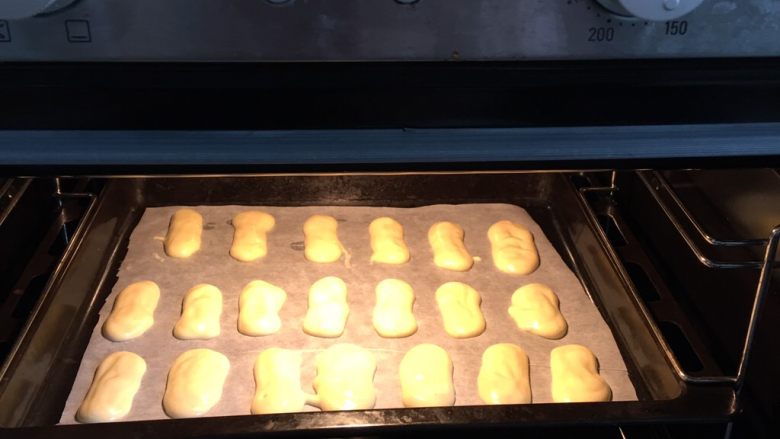 提拉米苏蛋糕,一根根挤在有油纸的烤盘里，烤箱预热五分钟，中层上下火，170度烤20分钟。