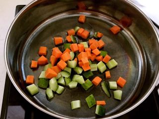 什锦虾仁,锅里加入1勺大豆色拉油，烧热后加入胡萝卜和黄瓜丁翻炒1分钟
