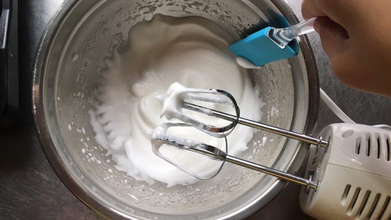 宝宝零食酸奶溶豆,打几下糖和蛋白融合，用刮刀将飞溅在盆壁的蛋白刮至中间，为的全都可以打到。然后打蛋器转低速继续打发，低速为了消除蛋白中的大气泡，使蛋白更细腻。