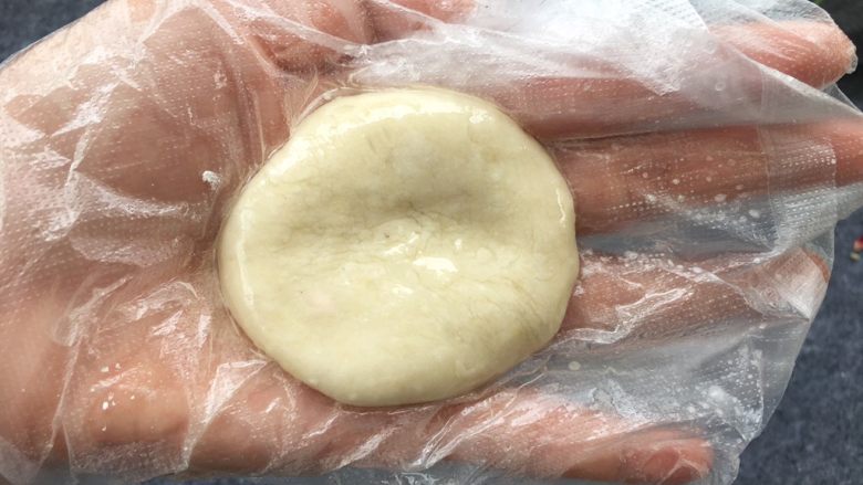 柿子糯米糍,糯米粉凉透后，准备一块保鲜膜或戴上一次性手套，防止粘手。保鲜膜上刷一点点油，把糯米团压扁。