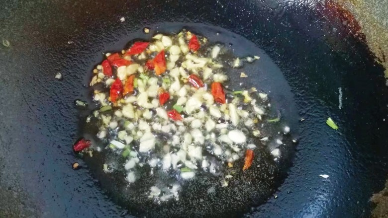 火腿鸡蛋炒面,锅中入适量油，下入蒜末和辣椒煸出香味；