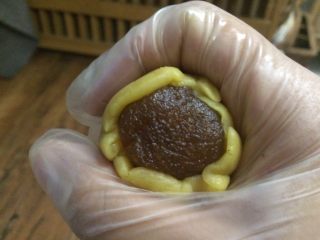 五彩桃山皮月饼,用虎口慢慢推，如果皮有点干，可以在手套上抹上一点点油，防止裂开。