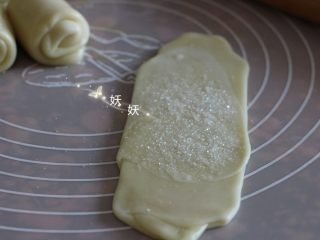 酥掉渣烧饼,翻面，如图，中间部分撒上一些白砂糖，如果不喜欢甜，这一步把糖换成小香葱碎。