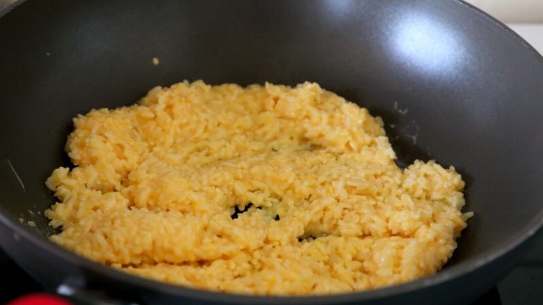 香甜米饭+黄金炒饭,7.油锅烧热，倒入拌好蛋液的米饭和葱白翻炒。
