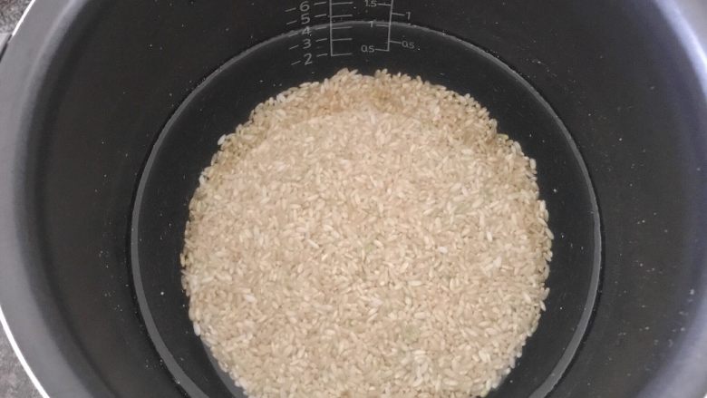 培根芸豆焖糙米饭,首先我们将黄糙米用水浸泡一个晚上（这样米粒吃的时候就会变软了，一定要这么做，要不然你试试，嘿嘿……樱桃这个有经验）。