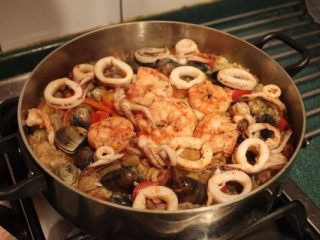 香甜米饭+西班牙海鲜饭,转小火，摆上虾子﹑蛤蜊，不要拌动。等到蛤蜊打开，约需5-10分钟