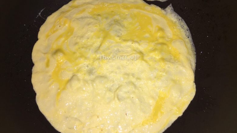 蛋包饭,中小火，倒入鸡蛋液，转动煎锅，使鸡蛋液转成圆形饼状，慢慢煎至凝固