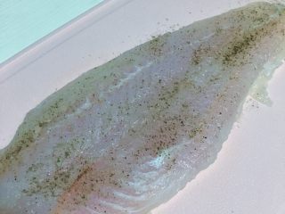 柠香龙利鱼,食材处理二：吸干水分后的龙利鱼表面抹上少许的黑胡椒粉 