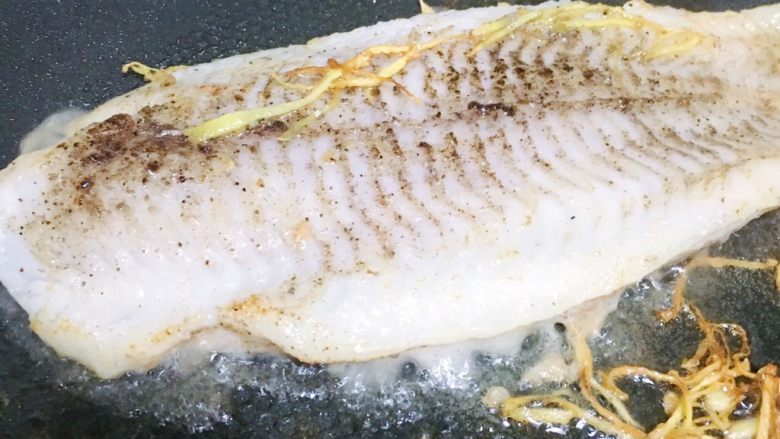 柠香龙利鱼,龙利鱼在煎的过程容易散开 所以翻面的时候要小心 煎至两面金黄 （姜丝这时候可以捞出 用于一会摆盘）