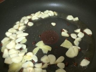干煸香辣护心肉,锅中放入8g油、放入花椒粒1.5g、姜片、蒜片爆香