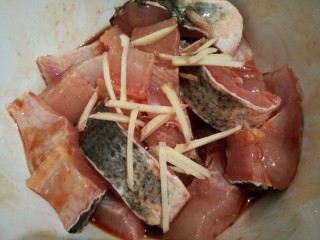 麻辣鲜香黑鱼块,生姜丝少许，拌均匀，盖保鲜膜放冰箱腌制一小时，腌制好以后，把黑鱼一块一块挑出来，裹上玉米淀粉