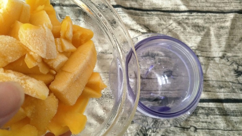 #网红甜点DIY家庭手做#芒果花思慕雪碗,将冻好的芒果粒倒入料理机