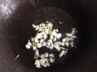 茭白炒肉丝,另起一锅，加入适量油，放入大蒜和葱白，炒香