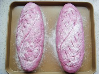 紫薯软欧包,再次发酵至稍微变大，撒上薄薄的一层干面粉，用锋利的刀片随意割出喜欢的花纹。