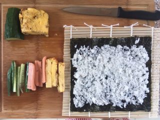 自制寿司,把米饭铺在紫菜上，前后都空1cm左右