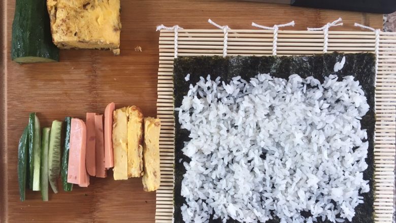 自制寿司,把米饭铺在紫菜上，前后都空1cm左右