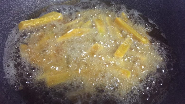 停不下来的小菜—蛋黄焗南瓜,热锅倒油，油热下南瓜炸熟