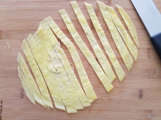 菠萝蛋包饭,将蛋饼切成食指宽的条。